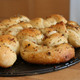 Plate of golden garlic knots dusted with herb seasonings